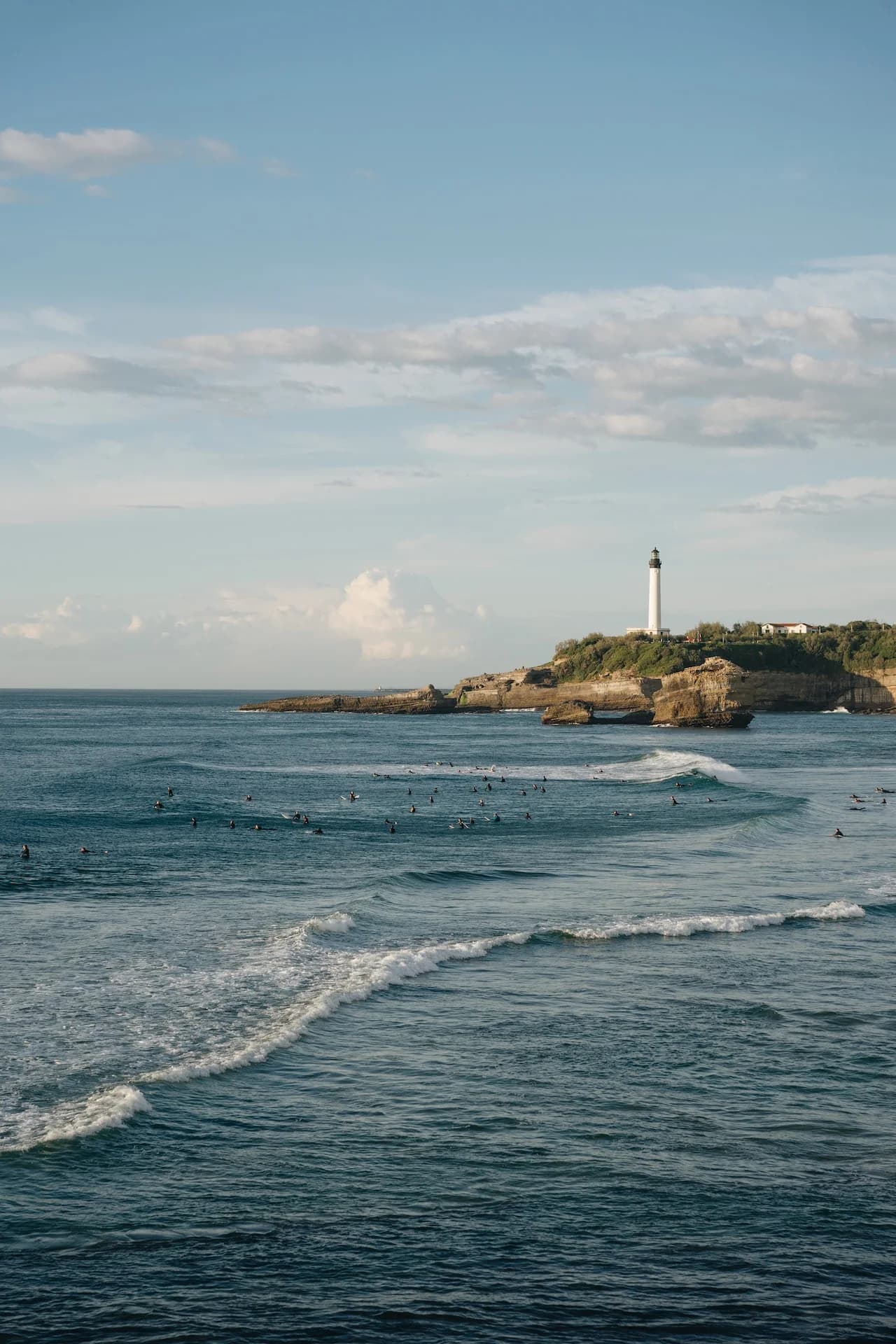 Lighthouse on a rocky coastline with ocean waves